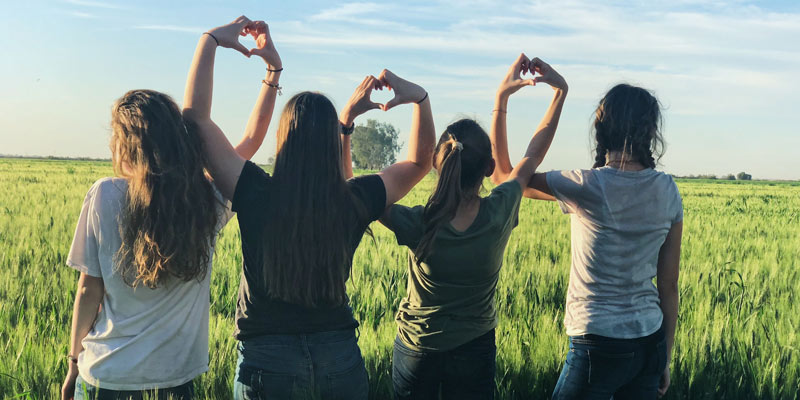 Frauen machen Herzen mit Fingern